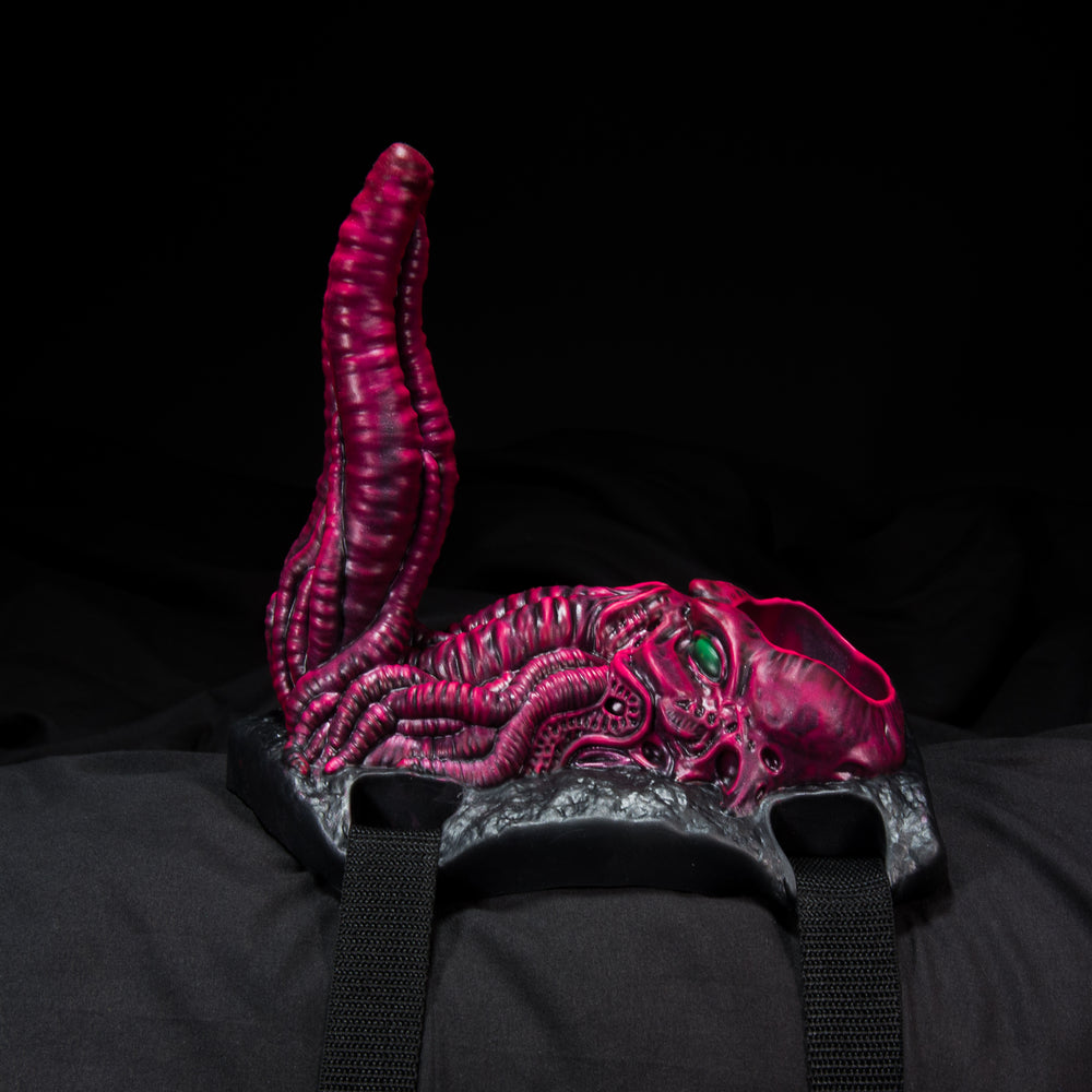 Cthulhu Tentacle Sex Toy in pink and black on bedsheet