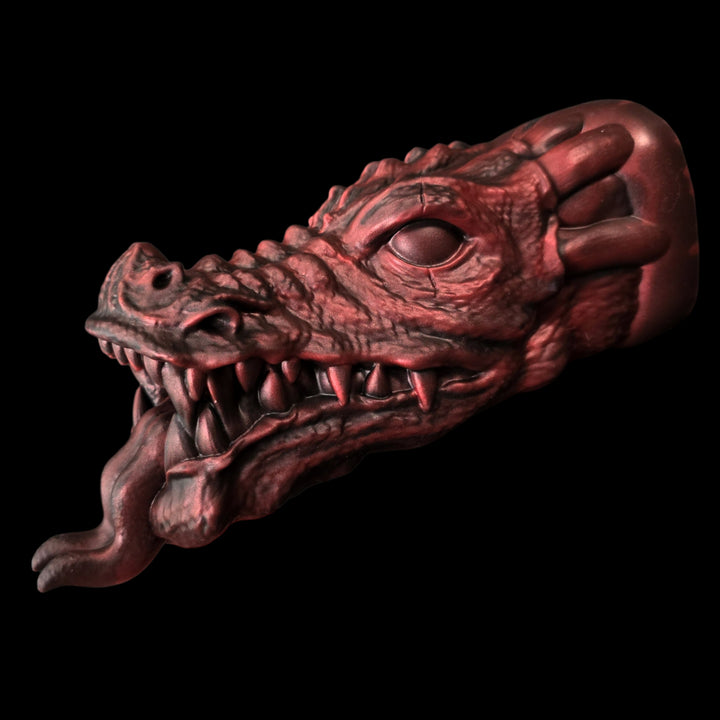 Red dragon head penetrable sex toy on a black background with tongue sticking out snarling