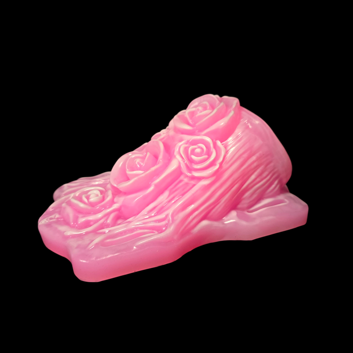 Pink fantasy sex toy with rose designs on a black background