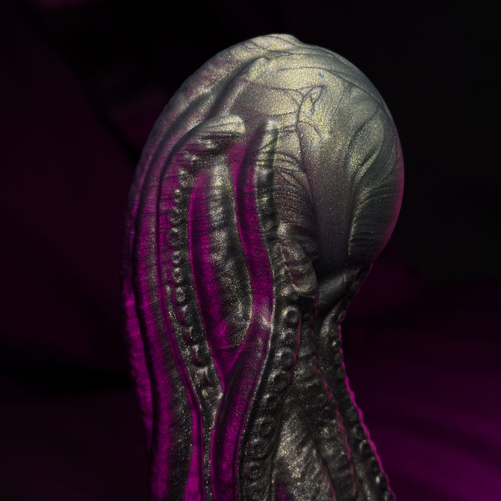 tentacles holding a pearl in green and black with purple hues