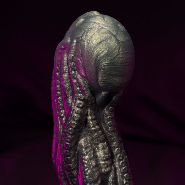 Close-up of a metallic object with pink interior on a dark background